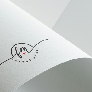 Minimalist design showcasing Favour Media logo on folded textured paper with copyspace.