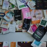 A vibrant collection of diverse coffee packaging displayed on a wall, highlighting design variety.