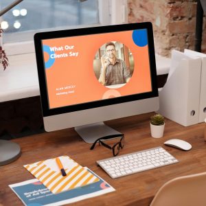 A modern home office setup with a desktop computer displaying a client testimonial on the screen.